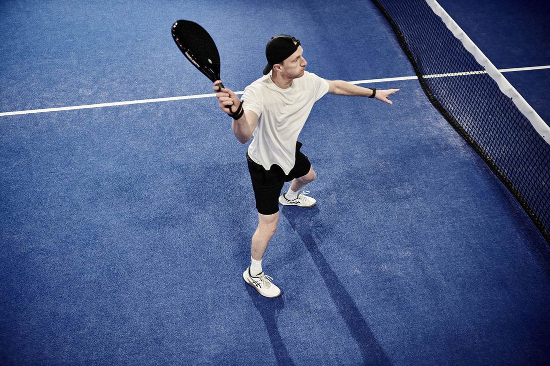 Padel player at the net striking a volley with a Padelsmith diamond-shape padel racket